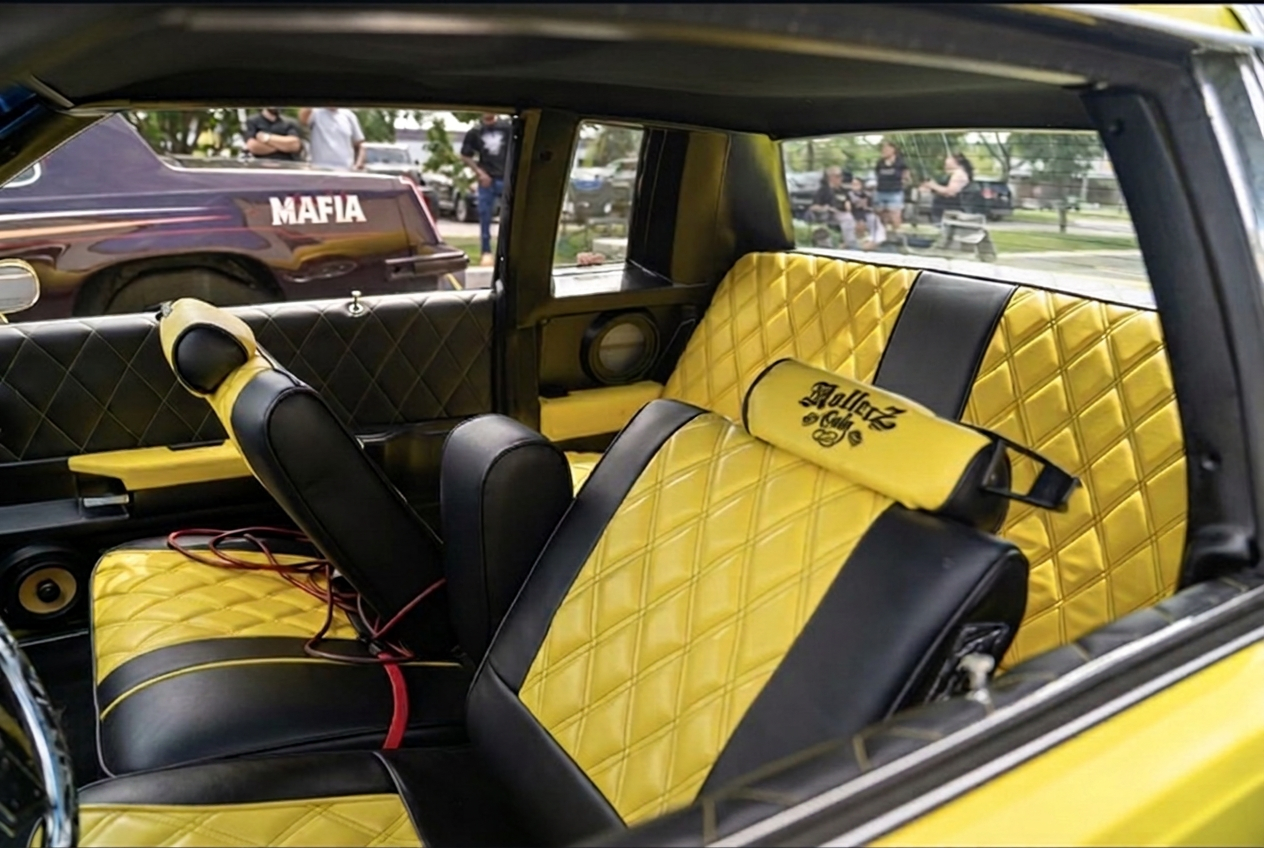 Yellow and black diamond-stitched custom lowrider interior with embroidered headrest