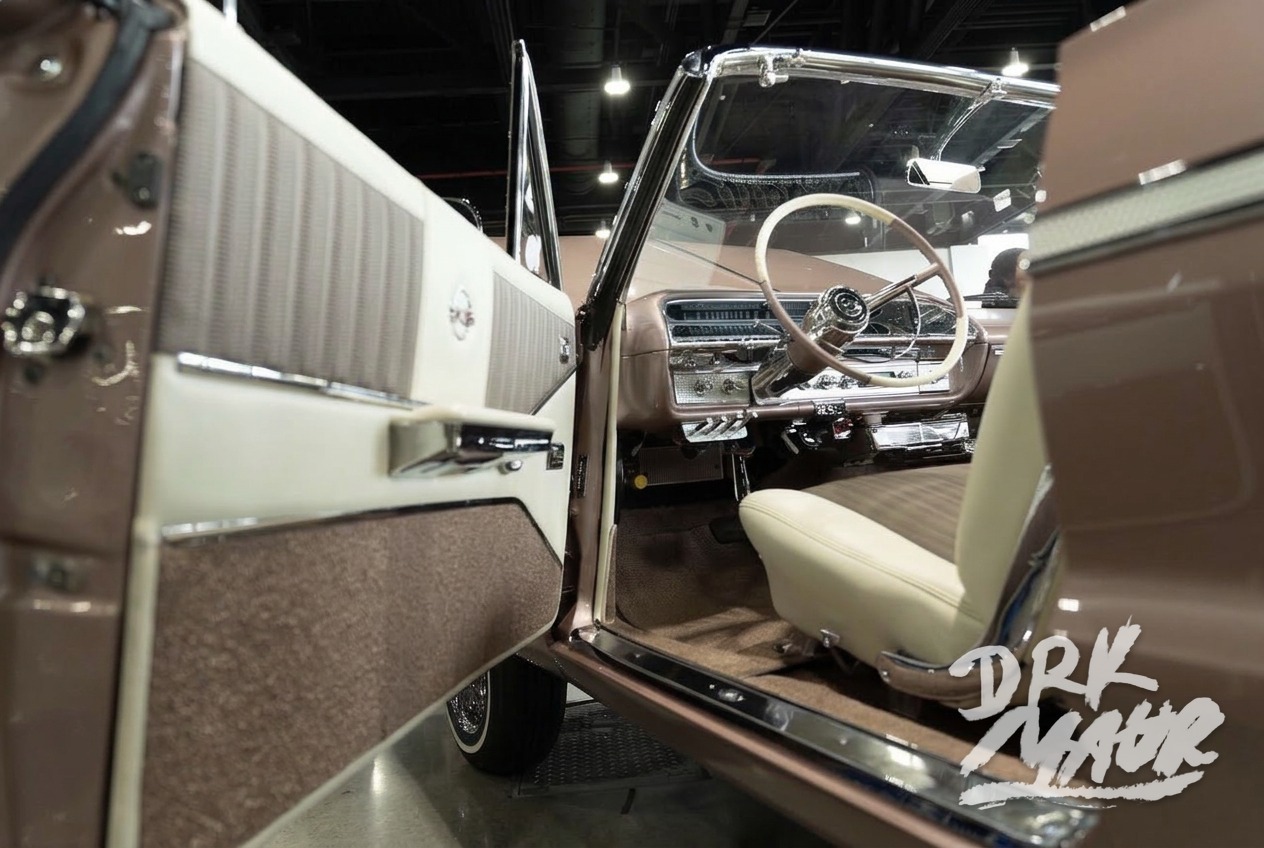 Cream and tweed custom interior of a rose gold Impala convertible with the door open at a car show