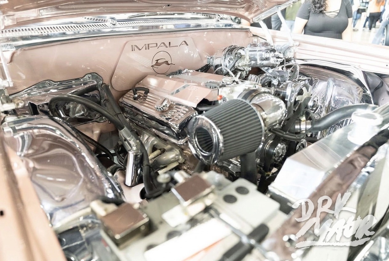 Chrome and rose gold detailed Chevrolet Impala engine bay with engraved valve covers and polished intake