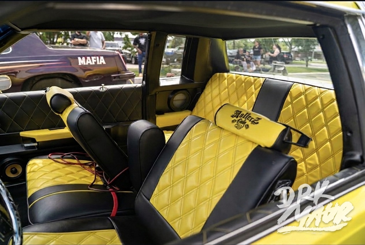 Yellow and black diamond-stitched custom lowrider interior with embroidered headrest
