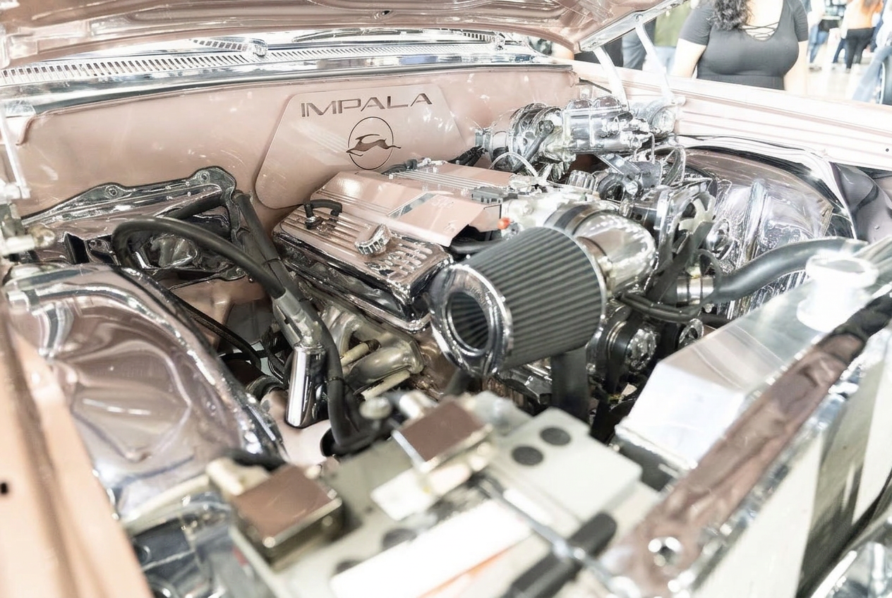 Chrome and rose gold detailed Chevrolet Impala engine bay with engraved valve covers and polished intake
